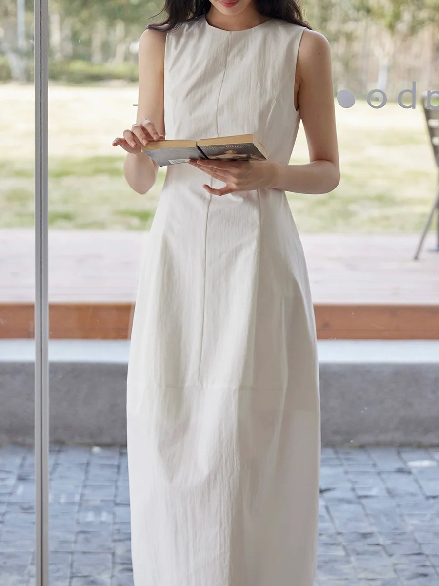 Sleeveless Maxi Dress Paired With a Woven Straw Handbag