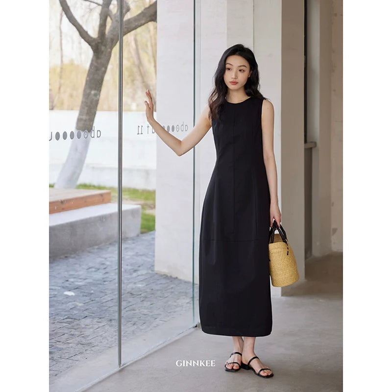 Sleeveless Maxi Dress Paired With a Woven Straw Handbag